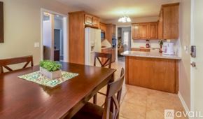 Broken Arrow house for rent - A kitchen with wooden cabinets and a table with a potted plant on it.