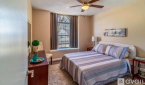 Broken Arrow house for rent - A bedroom with a bed, nightstand, and window.