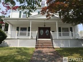 Quincy apartment for rent - A white house with a red door and a porch.