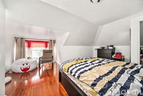 Quincy apartment for rent - A bedroom with a bed, a chair, and a pillow with a face on it.
