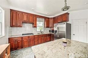Quincy apartment for rent - A kitchen with wooden cabinets and a marble countertop.