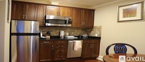Norwalk apartment for rent - A kitchen with wooden cabinets and a stainless steel refrigerator.
