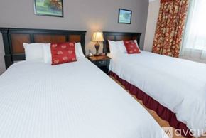 Norwalk apartment for rent - Two beds with white bedspreads and red pillows in a room.
