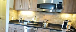 Norwalk apartment for rent - A kitchen with a black counter top and wooden cabinets.