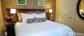 Norwalk apartment for rent - A well-lit bedroom with a large bed, floral vase, and framed pictures on the wall.