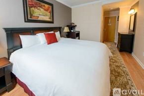 Norwalk apartment for rent - A bedroom with a large bed and a painting on the wall.