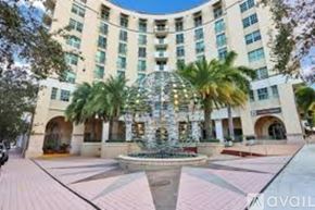 West Palm Beach condo for rent - A large building with a fountain in front of it.