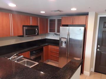 West Palm Beach condo for rent - A kitchen with a black granite counter top and stainless steel appliances.