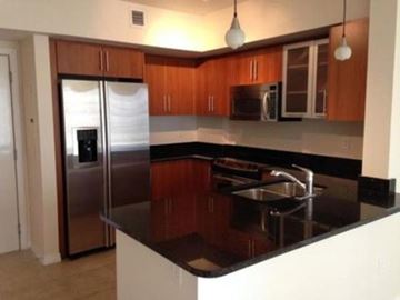 West Palm Beach condo for rent - A kitchen with a black counter top and stainless steel appliances.