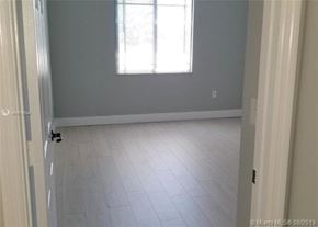 Palm Beach Gardens condo for rent - A room with a white tile floor and a window with blinds.