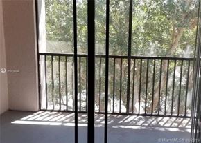 Palm Beach Gardens condo for rent - A balcony with a metal railing and a view of trees outside.