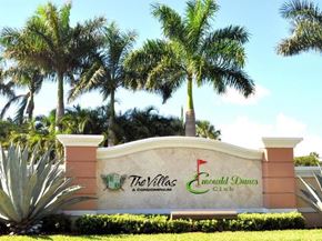 West Palm Beach condo for rent - The Villas at Emerald Dunes Club sign with palm trees in the background.