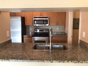 West Palm Beach condo for rent - A kitchen with granite countertops and stainless steel appliances.