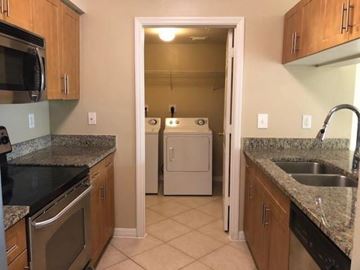West Palm Beach condo for rent - A kitchen with a white dishwasher and a microwave.
