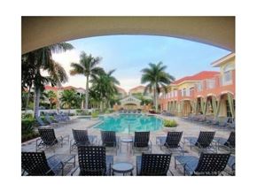Palm Beach Gardens condo for rent - A pool surrounded by chairs and palm trees.