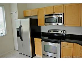 Palm Beach Gardens condo for rent - A kitchen with a stainless steel refrigerator, microwave, oven, and cabinets.