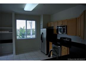Palm Beach Gardens condo for rent - A kitchen with black appliances and wooden cabinets.