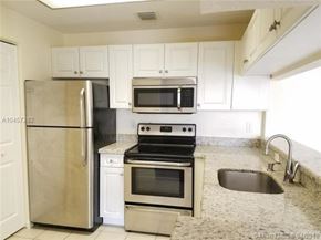 Palm Beach Gardens condo for rent - A kitchen with a stainless steel refrigerator, microwave, oven, and sink.