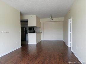 Palm Beach Gardens condo for rent - A spacious empty room with wood flooring and white walls.