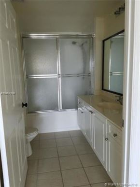 Palm Beach Gardens condo for rent - A white bathroom with a glass shower door and a white toilet.