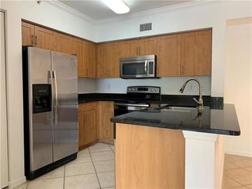 West Palm Beach condo for rent - A kitchen with a black counter top and wooden cabinets.