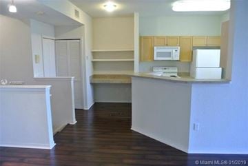 Palm Beach Gardens condo for rent - A kitchen with white cabinets and a microwave.