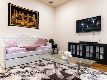 Irving apartment for rent - A living room with a white sofa and a television on the wall.