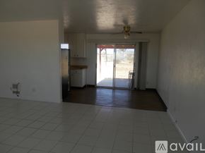 Landers house for rent - A spacious room with a ceiling fan and sliding glass doors leading to a backyard.