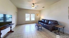 San Marcos house for rent - A white toilet sits next to a white bathtub in a tiled bathroom.