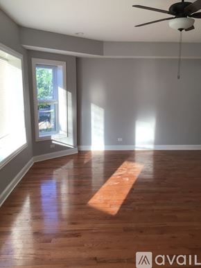 Chicago apartment for rent - A room with wooden floors and a ceiling fan.