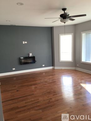Chicago apartment for rent - A room with a ceiling fan and wooden flooring.