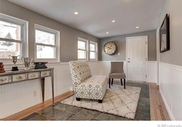 Englewood house for rent - A living room with a patterned chair and a clock on the wall.