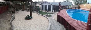 Palmdale apartment for rent - A pool with a wooden deck and a gravel area with a house in the background.