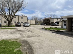 Pekin house for rent - A parking lot with several cars and buildings in the background.