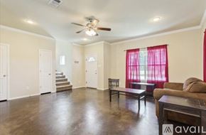 Waco house for rent - A living room with a couch, a coffee table, and a staircase.