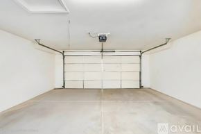 Marana house for rent - A spacious garage with a white door and a concrete floor.