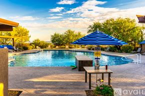 Marana house for rent - A pool with a table and chairs and umbrellas.