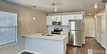 Oklahoma City house for rent - A kitchen with white cabinets and a stainless steel refrigerator.
