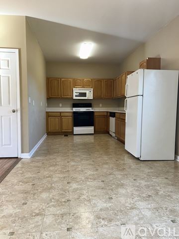 Sevierville apartment for rent - A kitchen with a white refrigerator and wooden cabinets.
