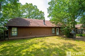 Sherwood house for rent - A brown house with a white door and a window is surrounded by trees.