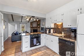 Sherwood house for rent - A kitchen with white cabinets and a black oven.