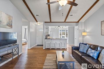 Sherwood house for rent - A living room with a brown leather couch and a wooden coffee table.