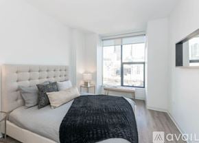 Chicago house for rent - A bedroom with a large bed and a window overlooking a cityscape.