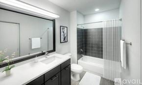 Chicago apartment for rent - A bathroom with a white sink, a toilet, and a shower with a glass door.