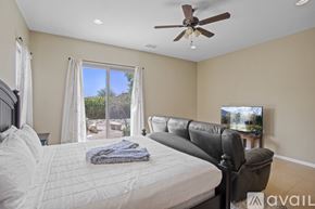 La Quinta house for rent - A bedroom with a large bed and a flat screen TV mounted on the wall.