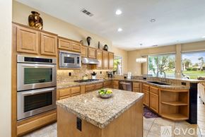 La Quinta house for rent - A kitchen with wooden cabinets and granite countertops.