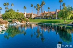 La Quinta house for rent - A house with a pool in front of it and palm trees in the background.
