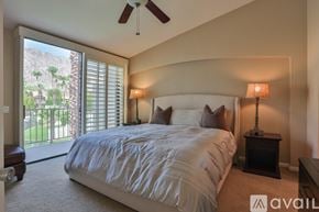 La Quinta house for rent - A bedroom with a large bed and a ceiling fan.