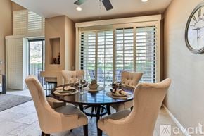 La Quinta house for rent - A dining room with a table set for four and a clock on the wall.