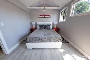 North Hollywood house for rent - A bedroom with a bed, two lamps, and a painting on the wall.